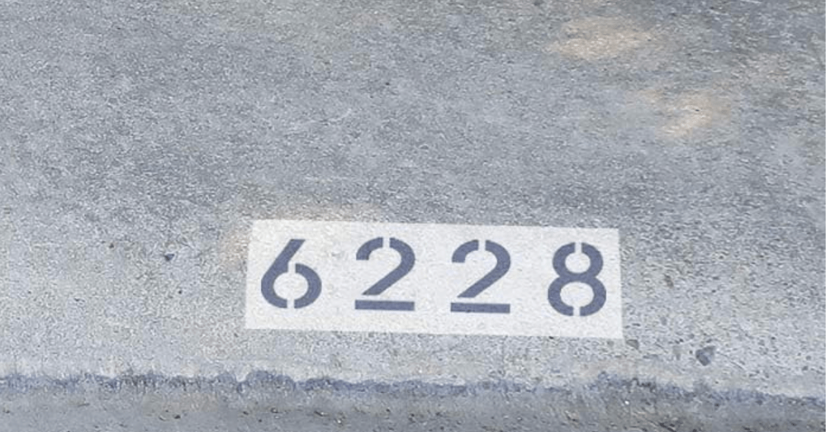 House numbers painted on sidewalk.