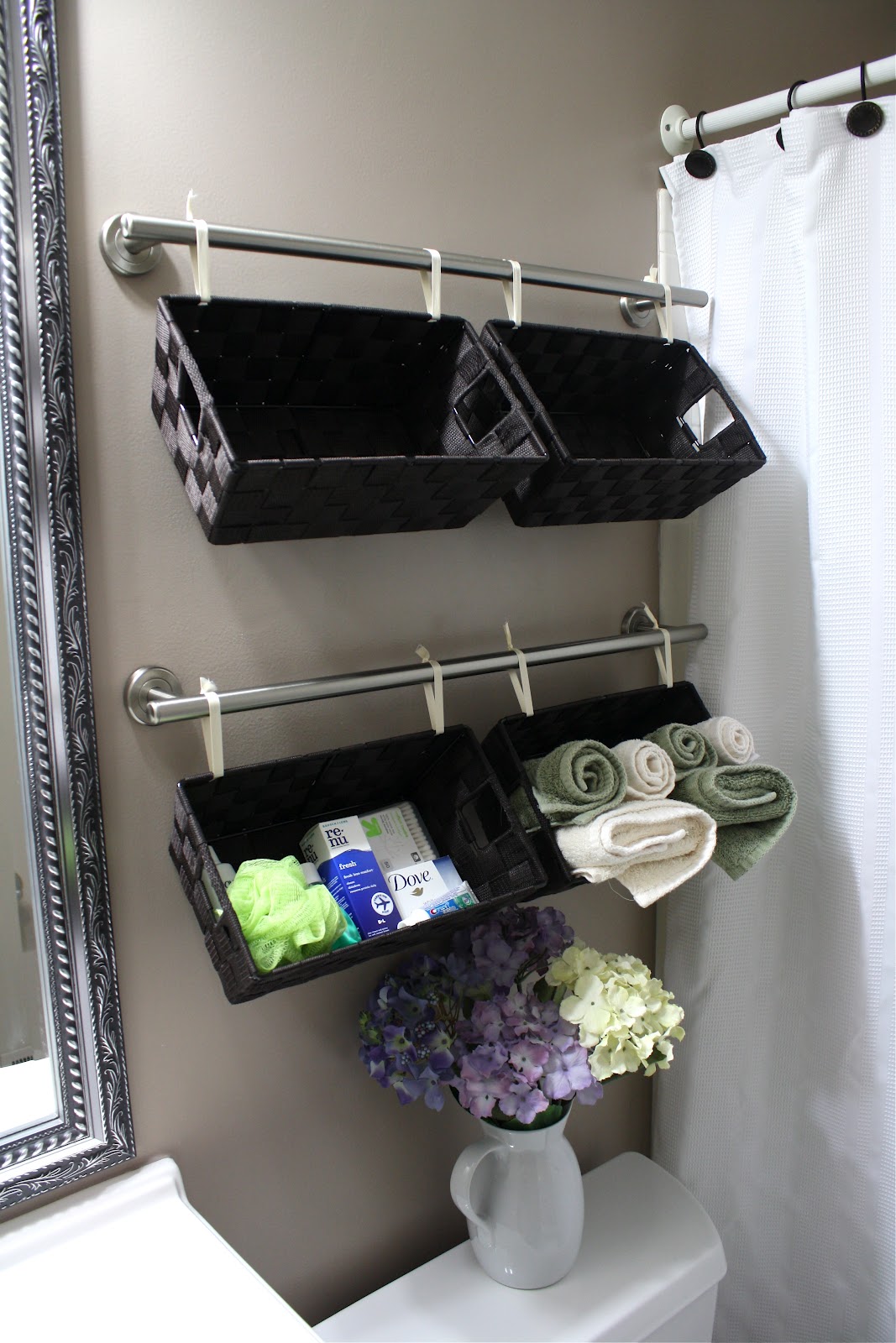 Baskets hanging on towel bars above toilet