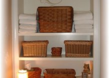 Brown baskets on white shelf above toilet