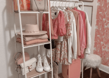 clothing rack with pink clothes in bedroom fluffy ottoman