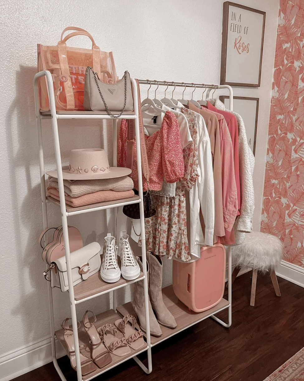 clothing rack with pink clothes in bedroom fluffy ottoman