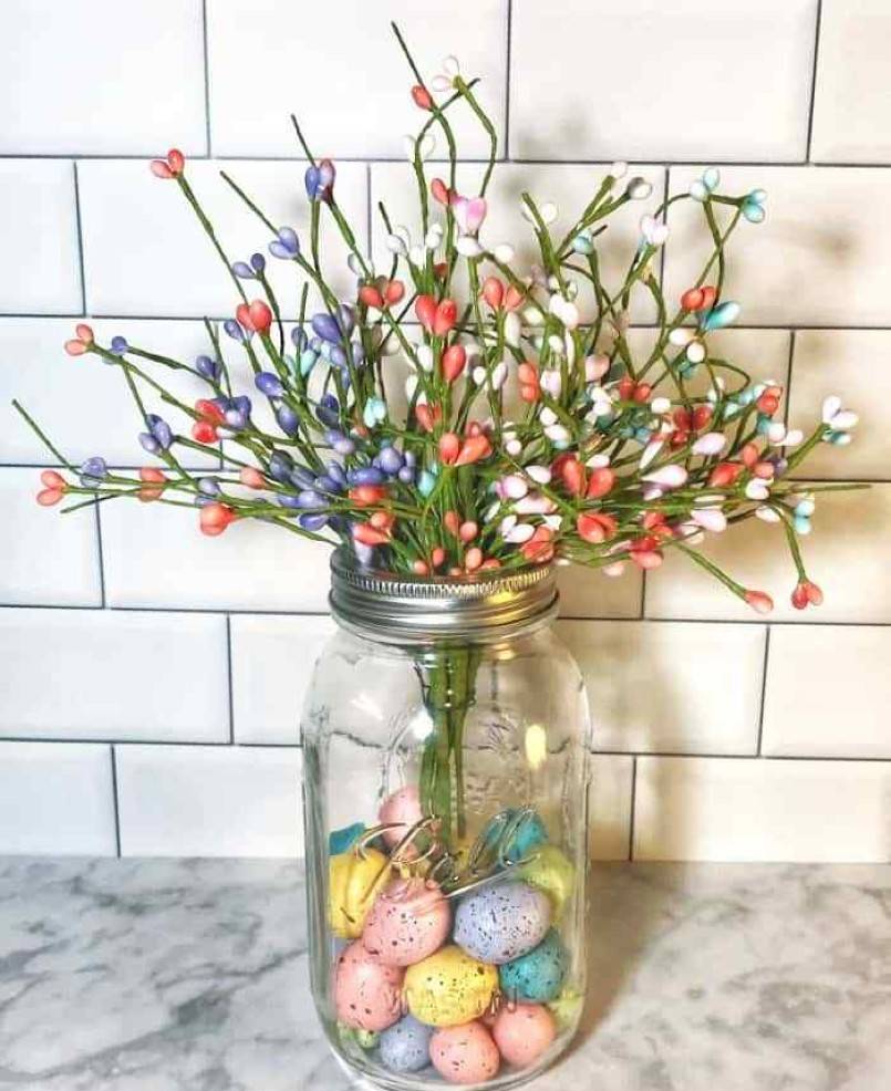Colorful eggs inside a mason jar with flowers