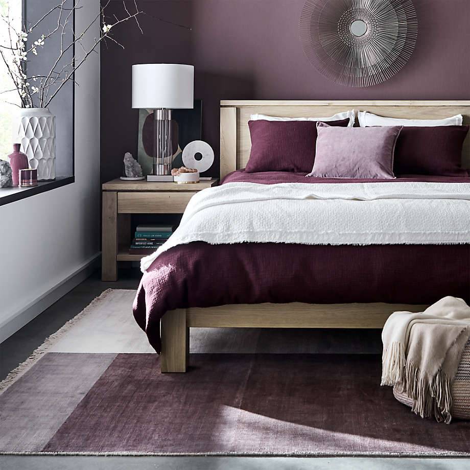 purple bedroom walls and linen on wooden bed frame