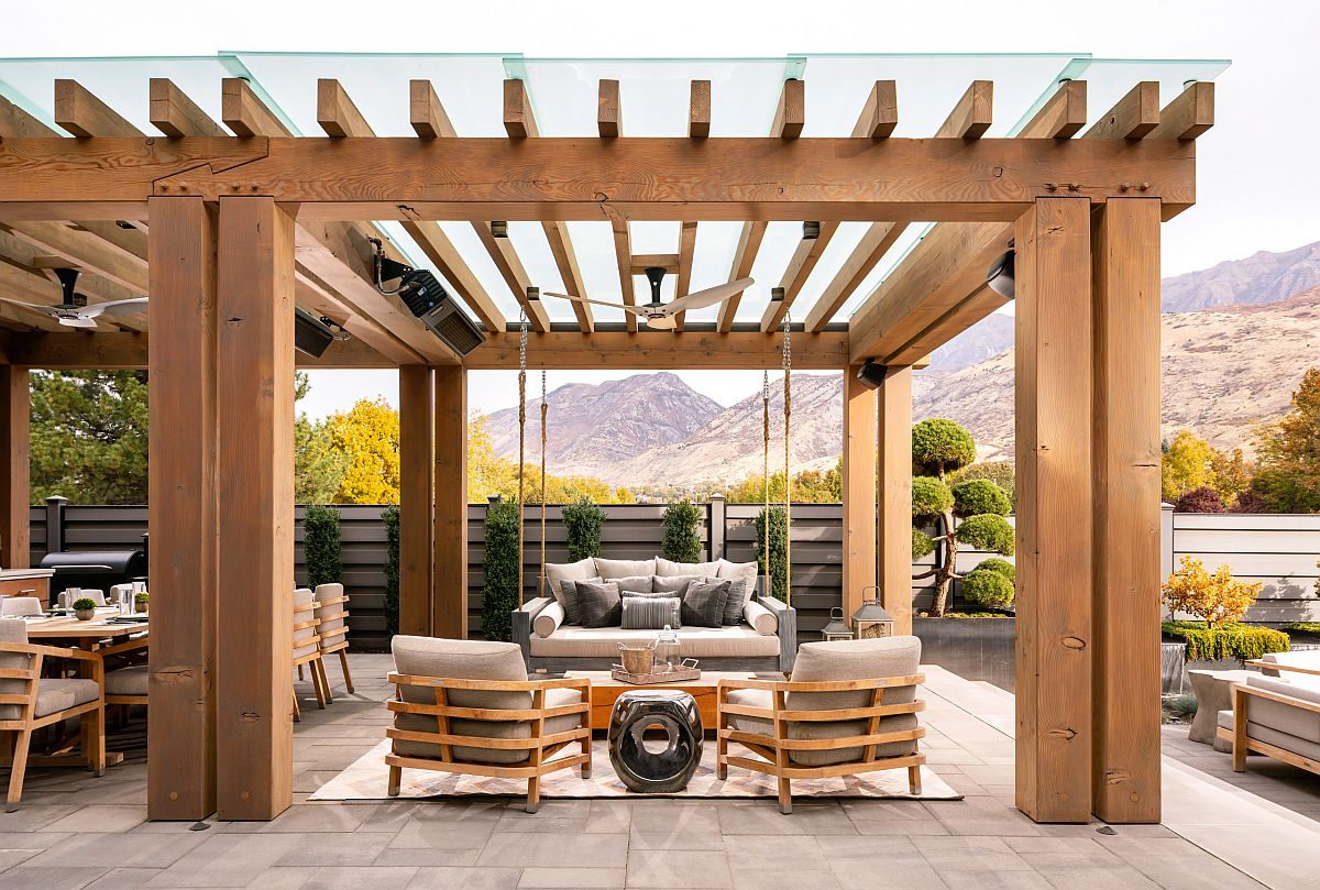 Exquisite wooden pergola structure with ceiling fan and comfy outdoor decor