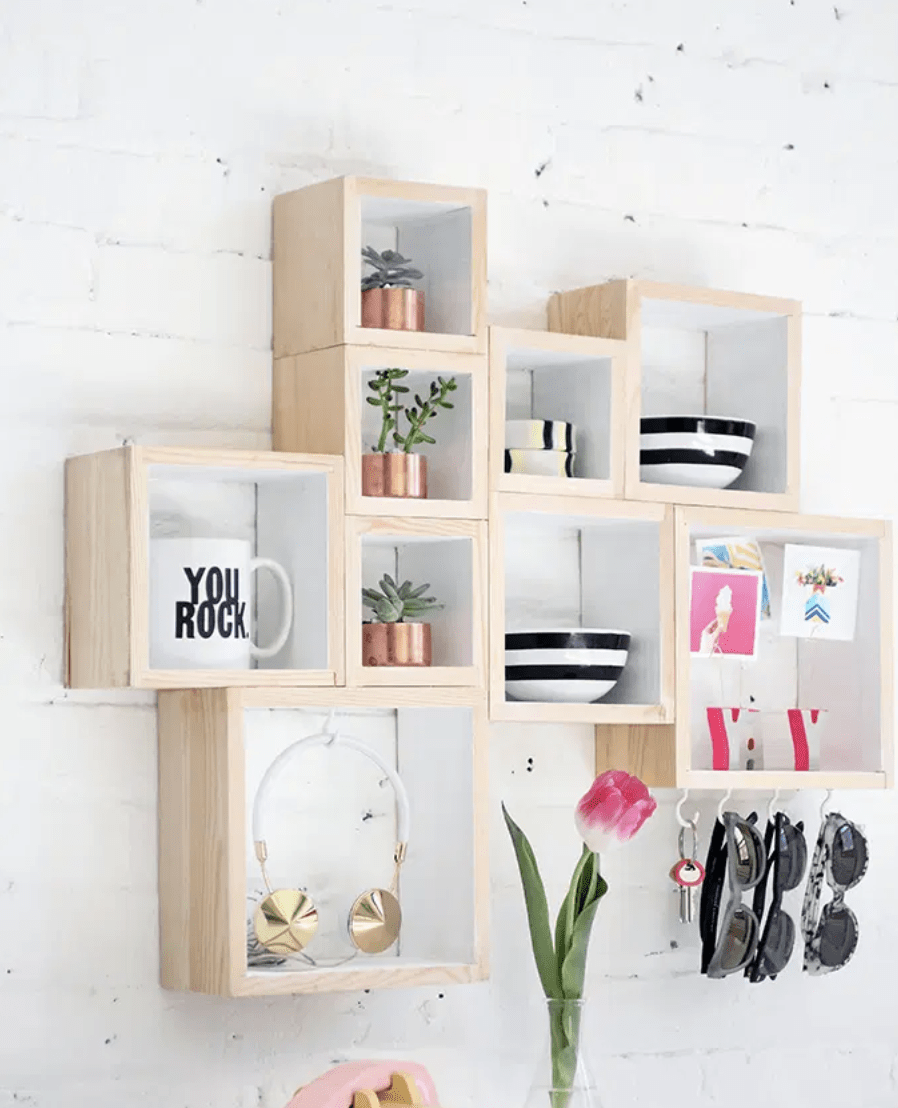 floating cube shelf on brick wall background cups sunglasses plants