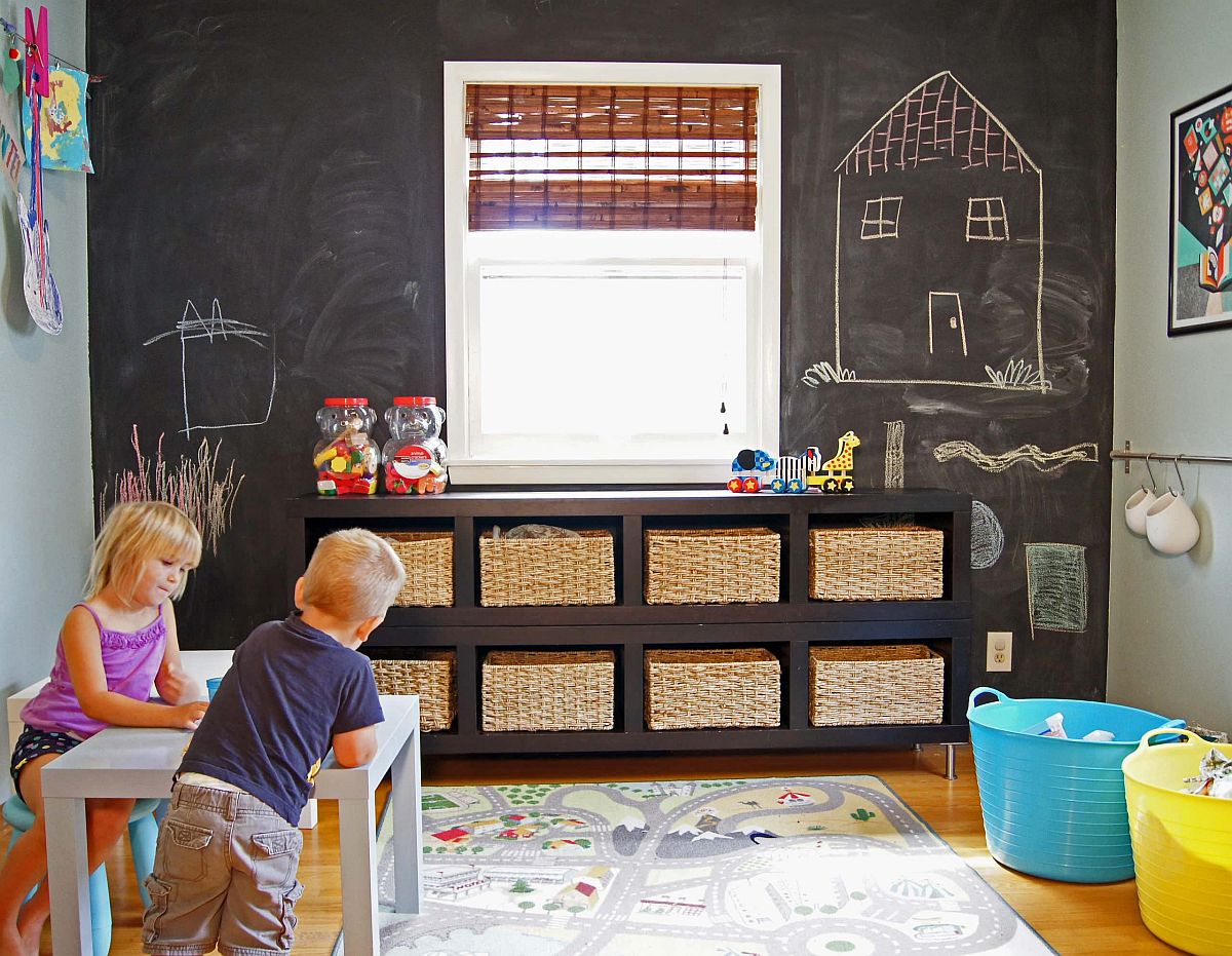 Fun playroom with small storage baskets for toys and a chalkboard wall in the backdrop