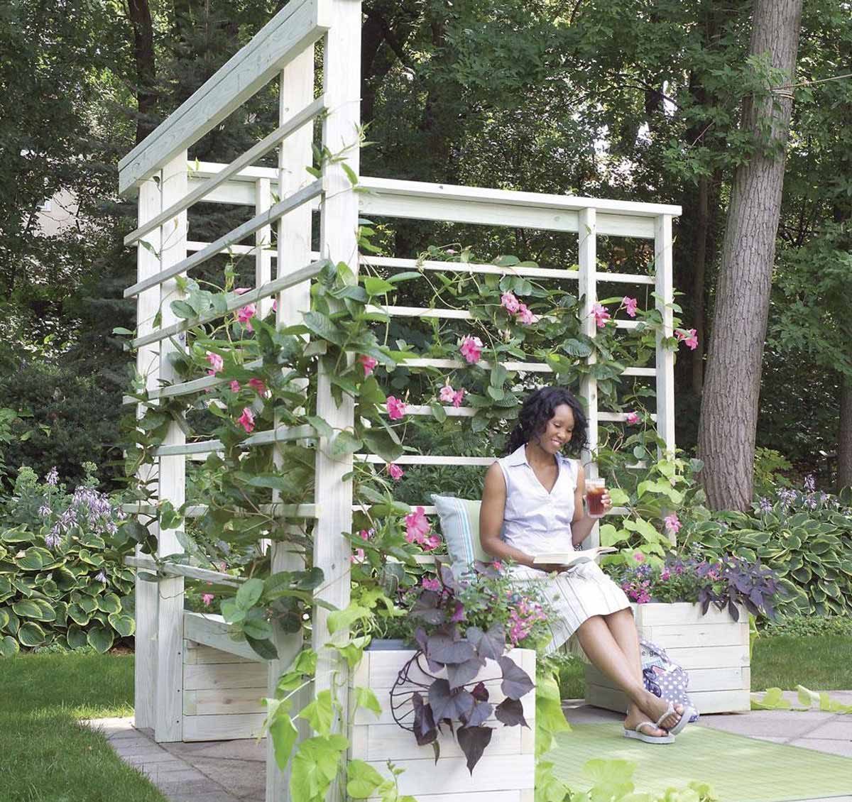 woman sitting on bench with hanging flowers