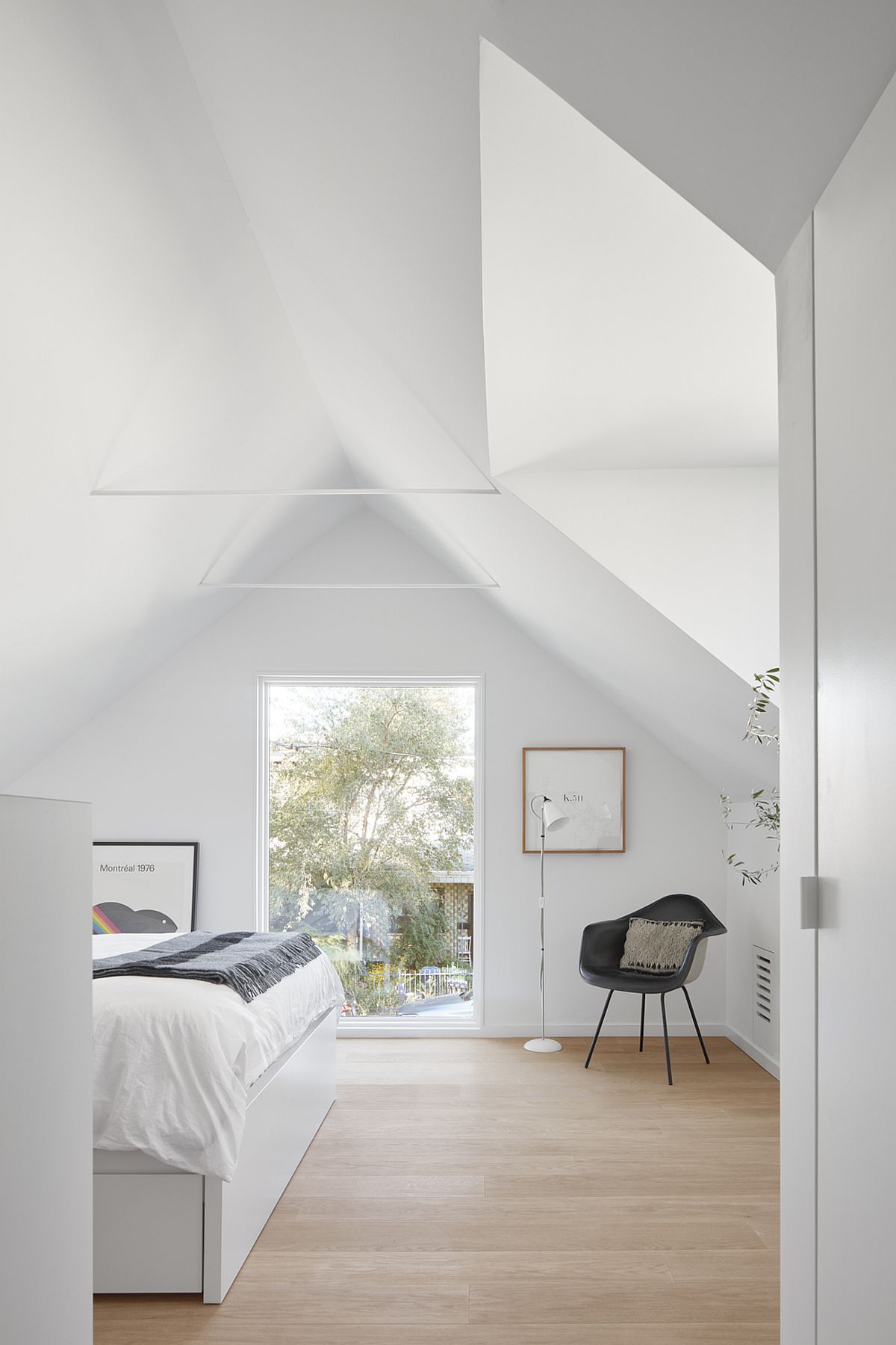 Glass window and skylight bring ample natural light into the bedroom on the upper level