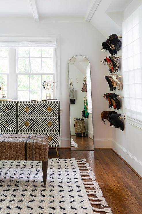 shoes hanging on a wall with mirror and dresser carpet