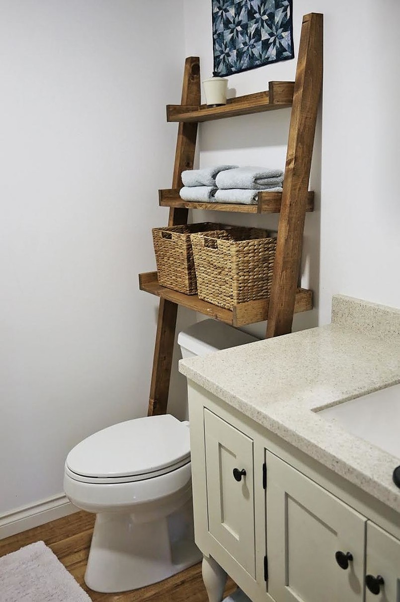 Ladder storage shelf leaning on the wall with wicker baskets and towels