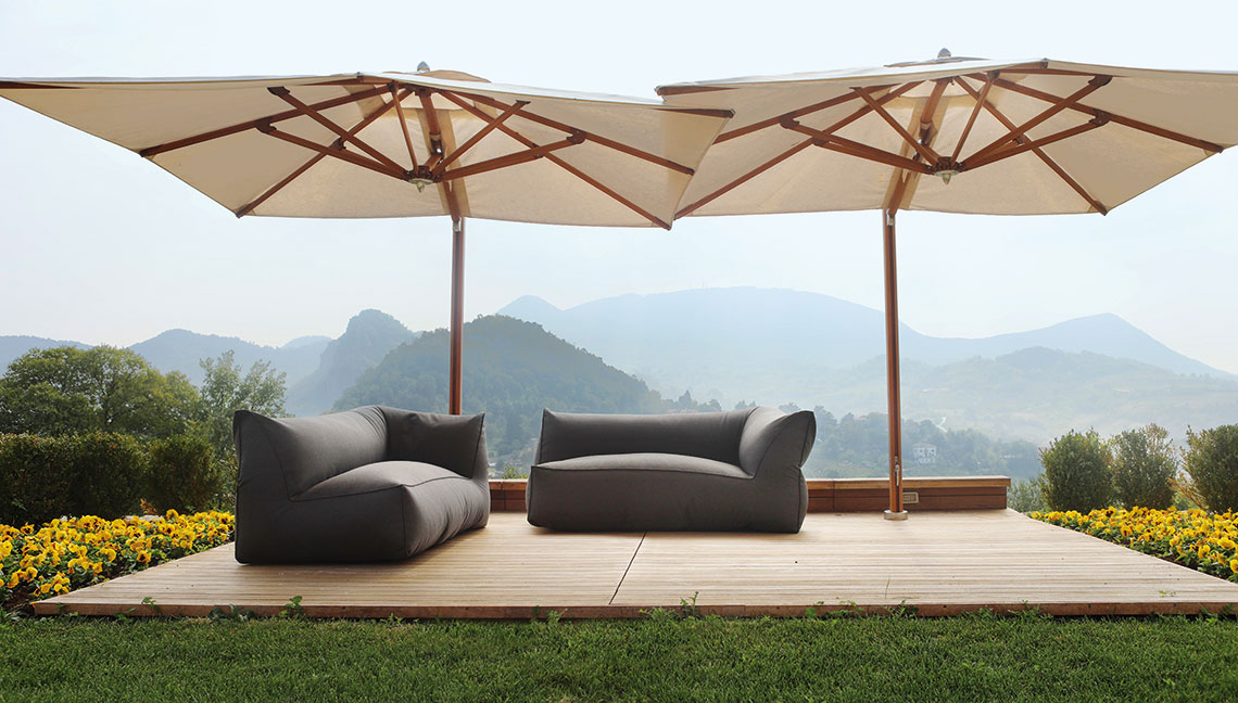 Large umbrellas shading two sofas on deck