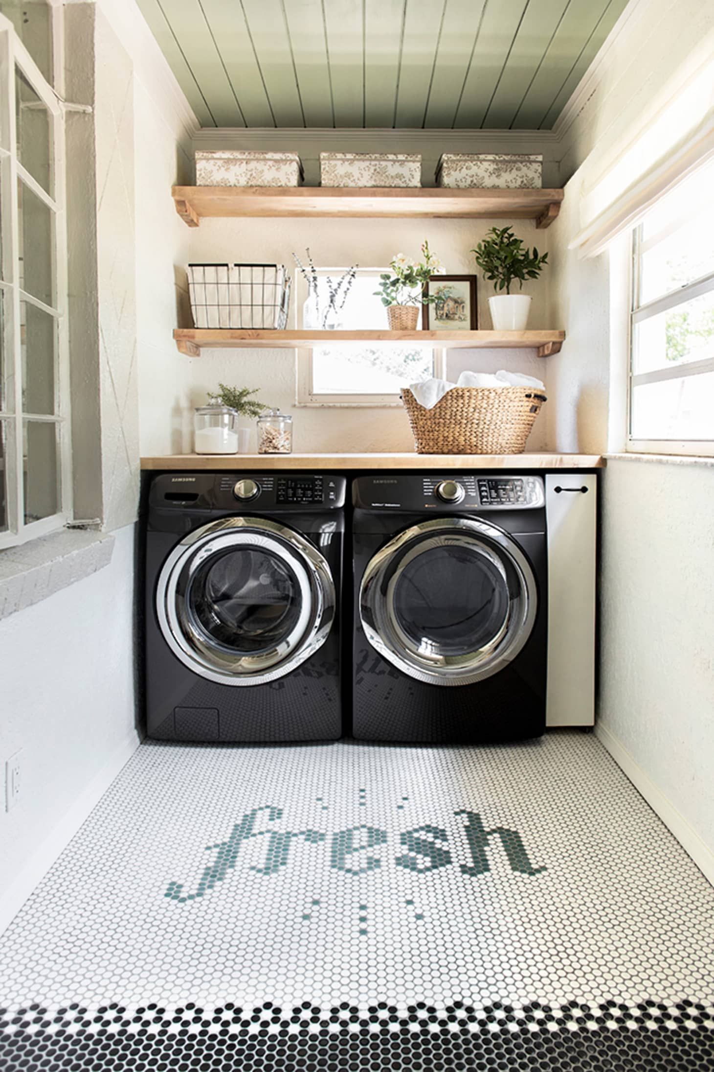 Laundry room with black washer and dryer and penny tile floor design