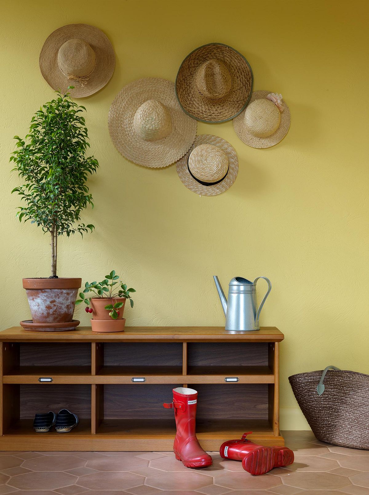 Mellow yellow accent wall for the contemporary entry wih space for boots and hats!