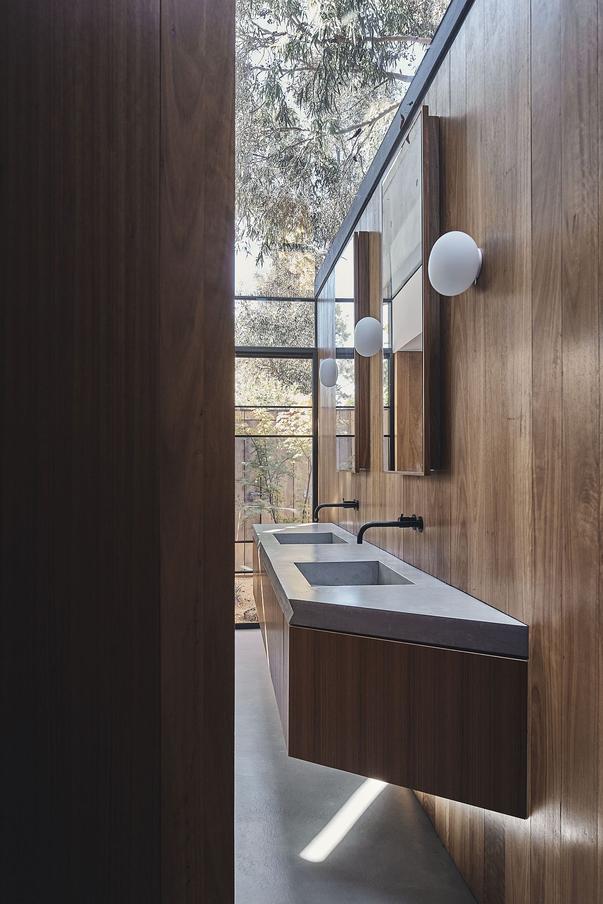 Minimal bathroom of the house with floating wooden vanity and a view of the outdoors