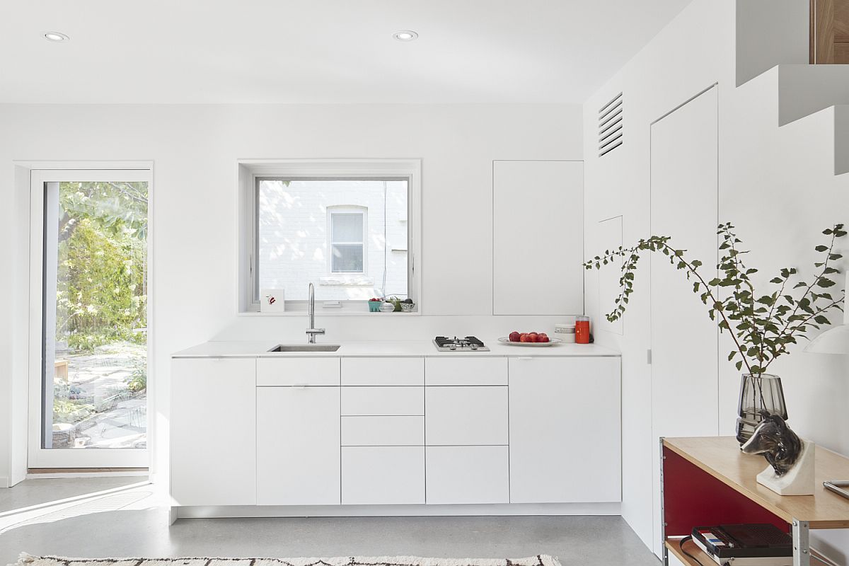 Modern, space-conscious kitchen in white inside small laneway house