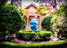 Native house with blue decoration surrounded by green plants