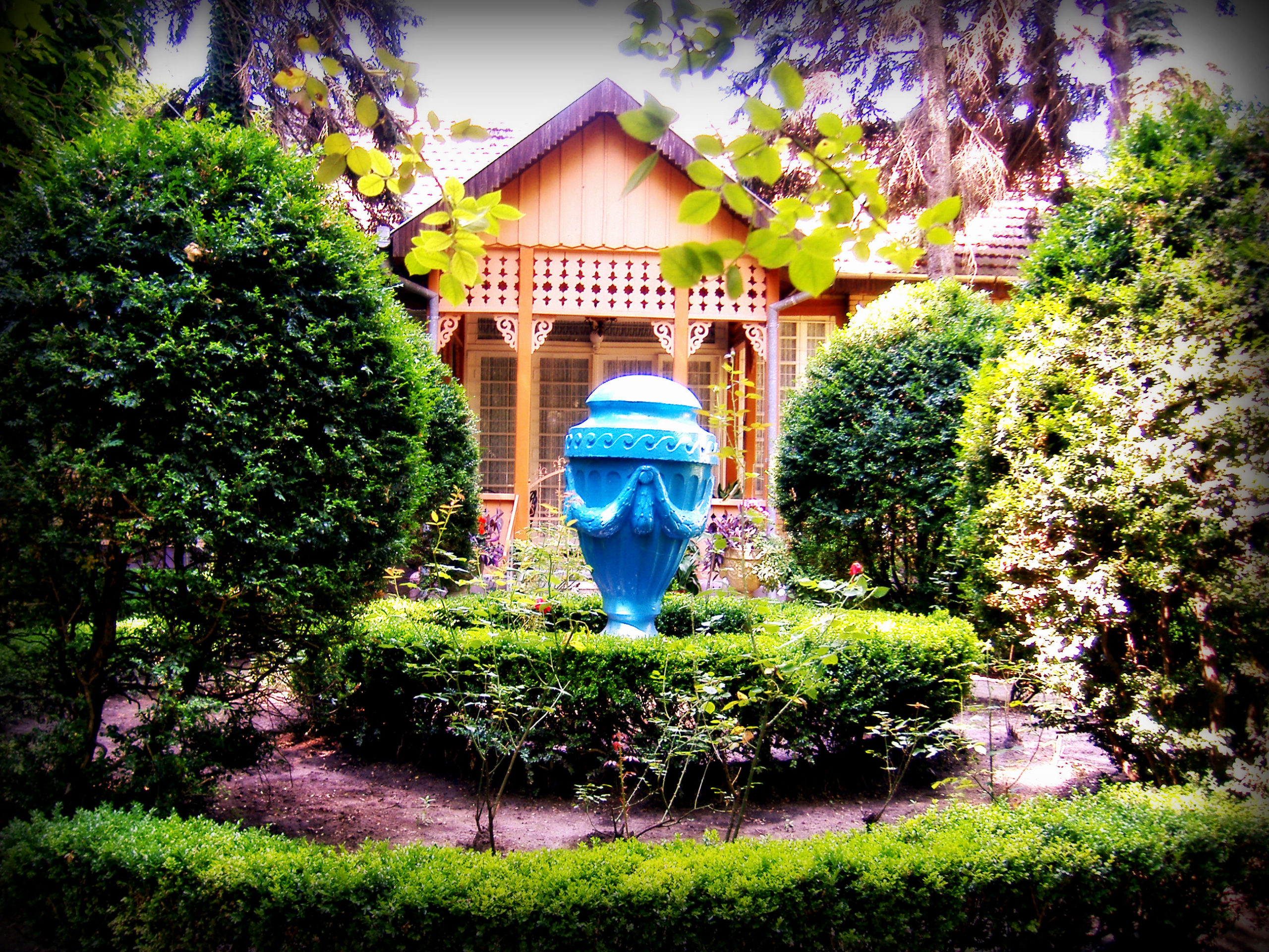 Native house with blue decoration surrounded by green plants