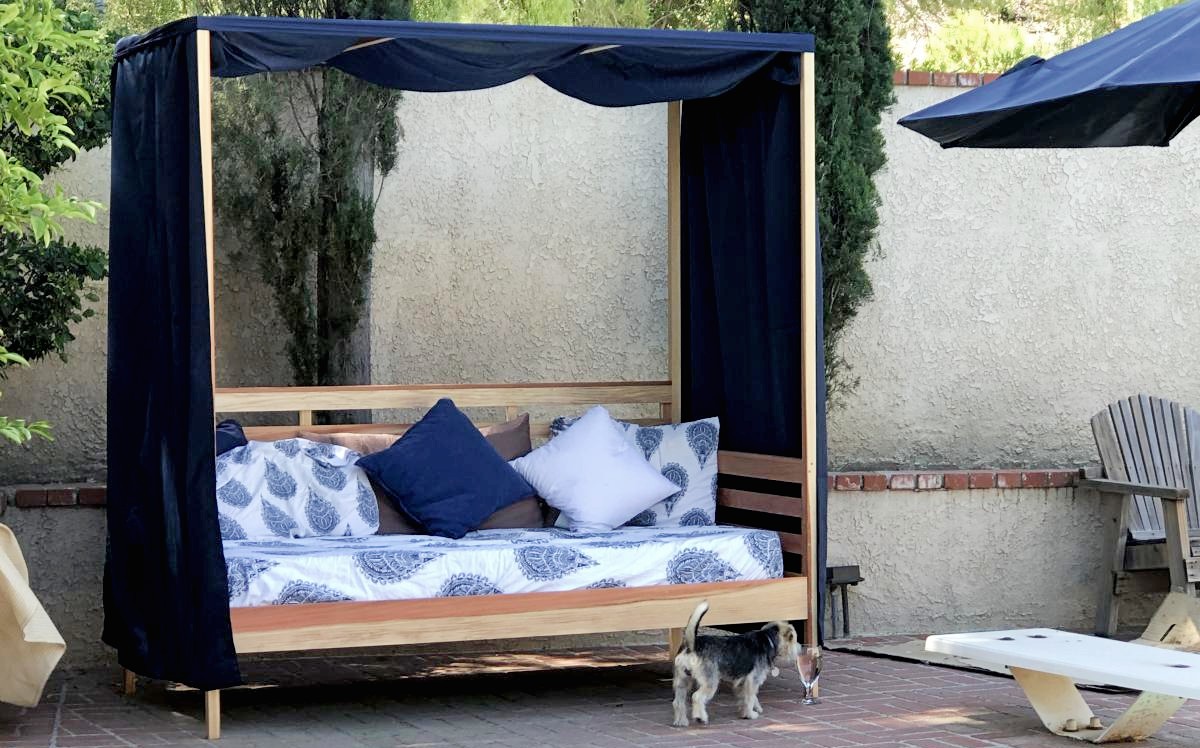 outdoor daybed with blue canopy and cushions