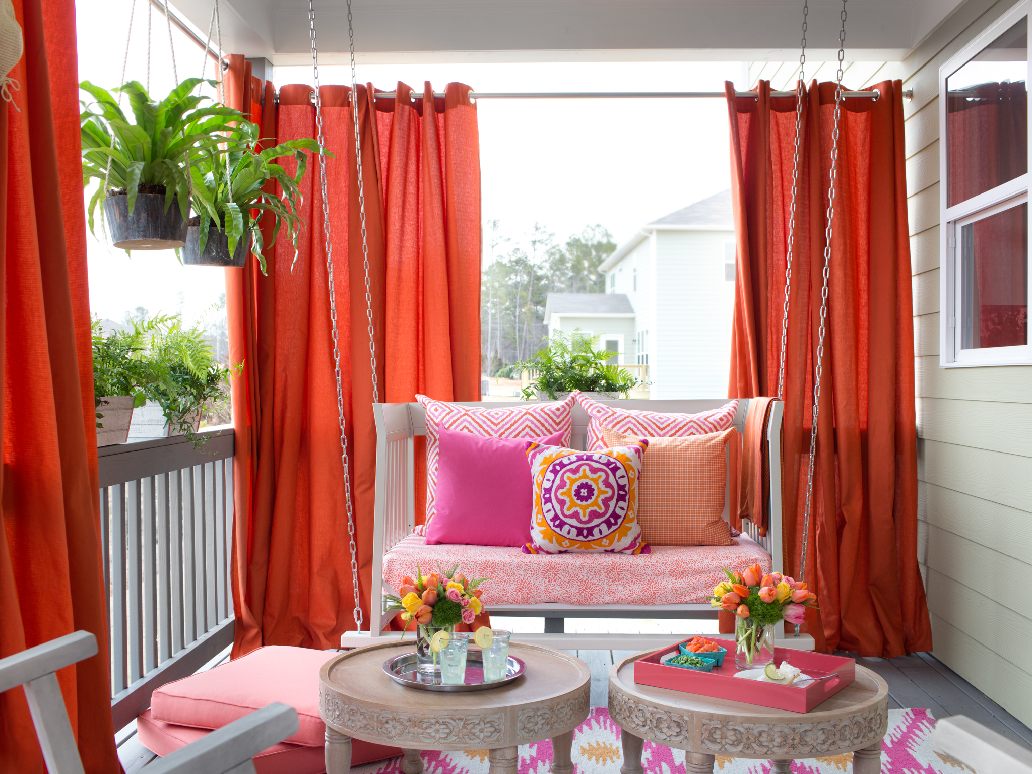 Vibrant Outdoor Space With Hanging Daybed and Draperies