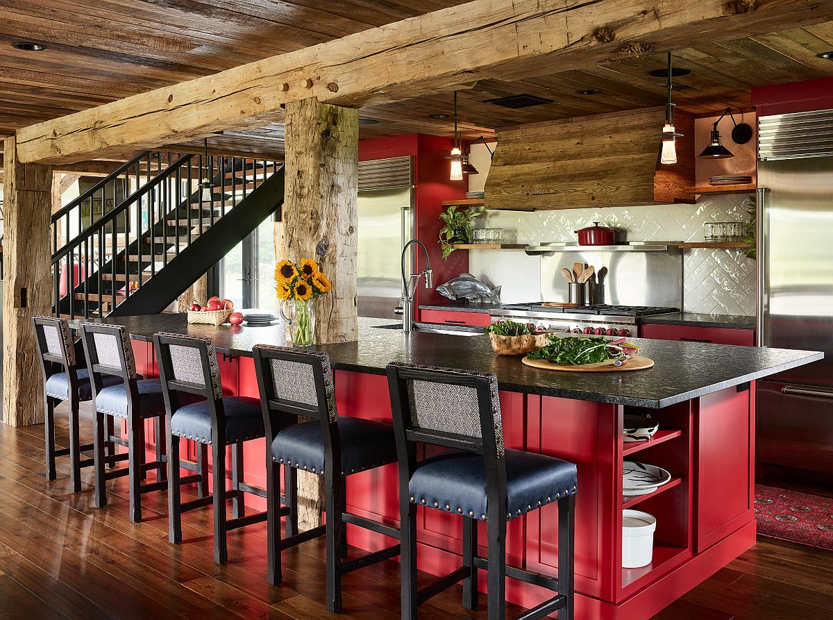 Red kitchen islands coupled with wooden cabinets in the spacious rustic kitchen