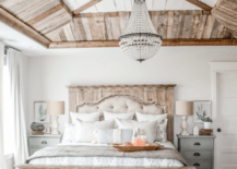 rustic master bedroom with crystal chandelier and distressed wood accents