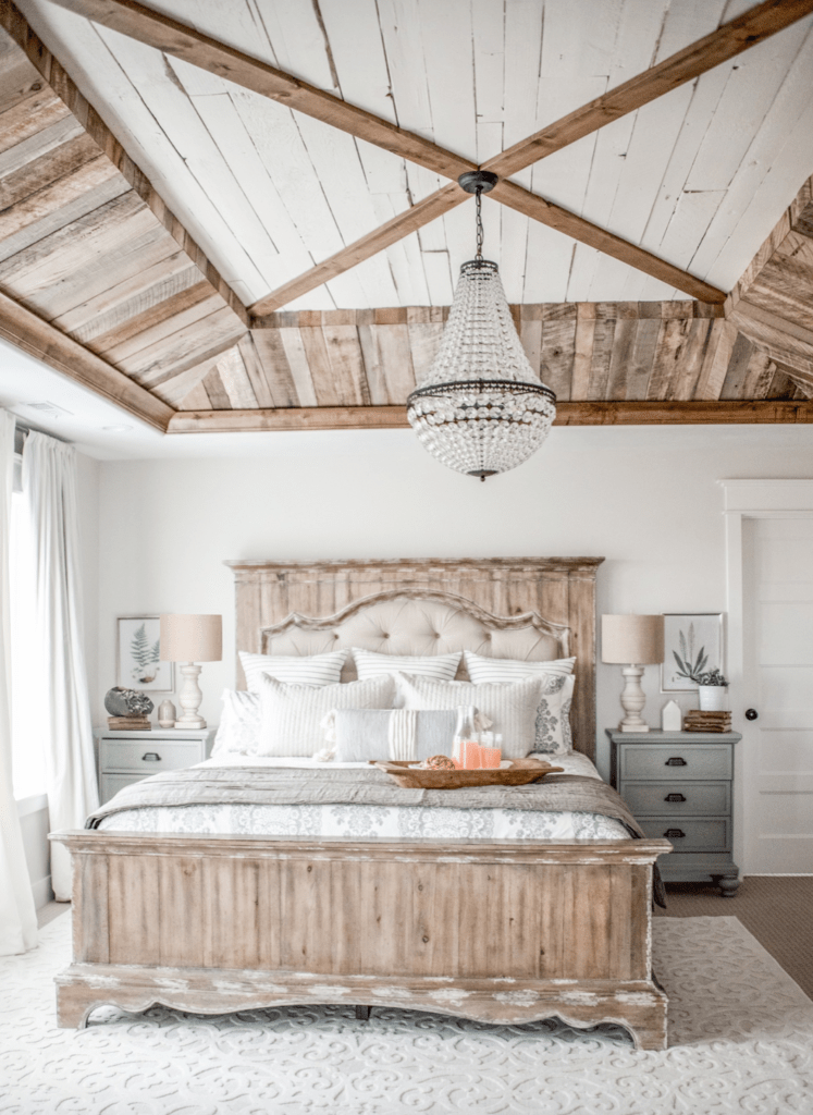 rustic master bedroom with crystal chandelier and distressed wood accents