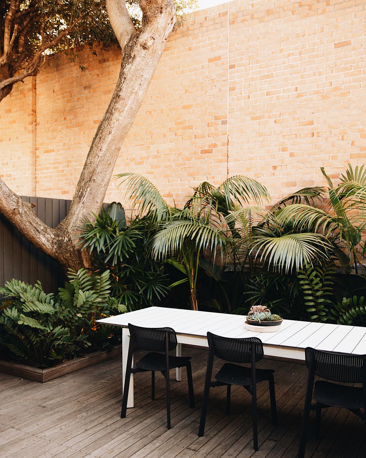 Small contemporary decor with brick wall backdrop and ample greenery all around