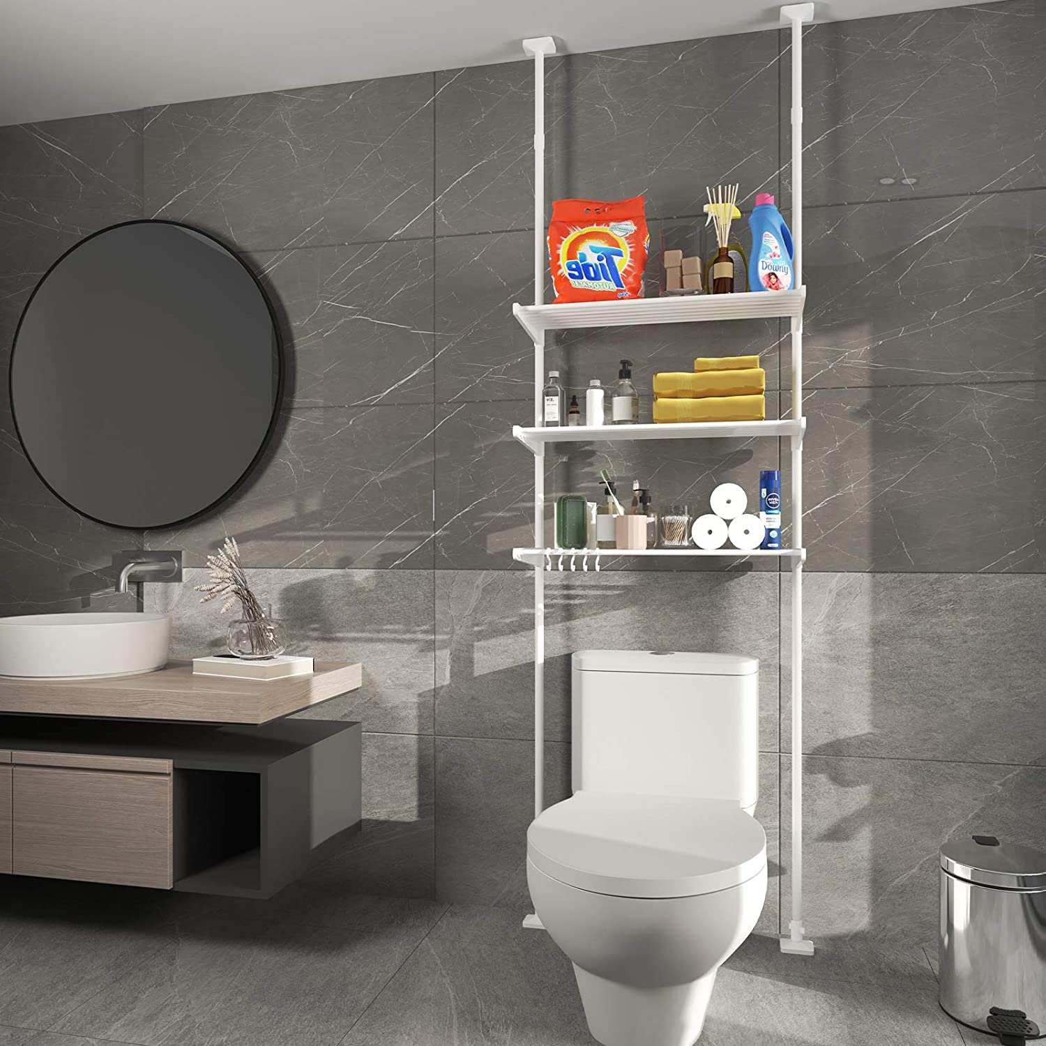 Three-layer adjustable shelf hooked from ceiling to wall in a gray tone bathroom with round mirror