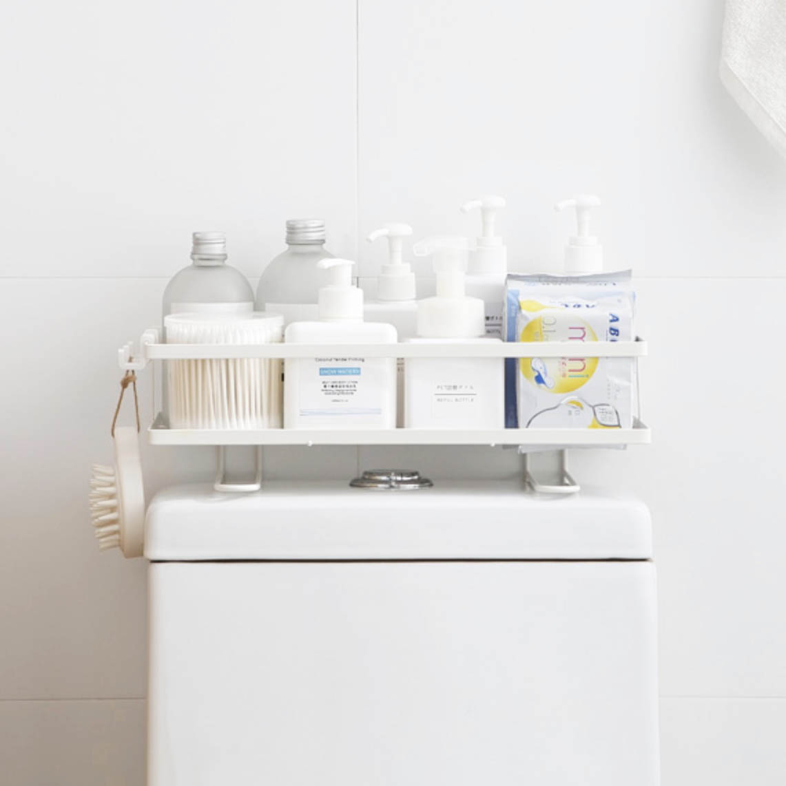 Toiletries in organizer rack placed on top of toilet