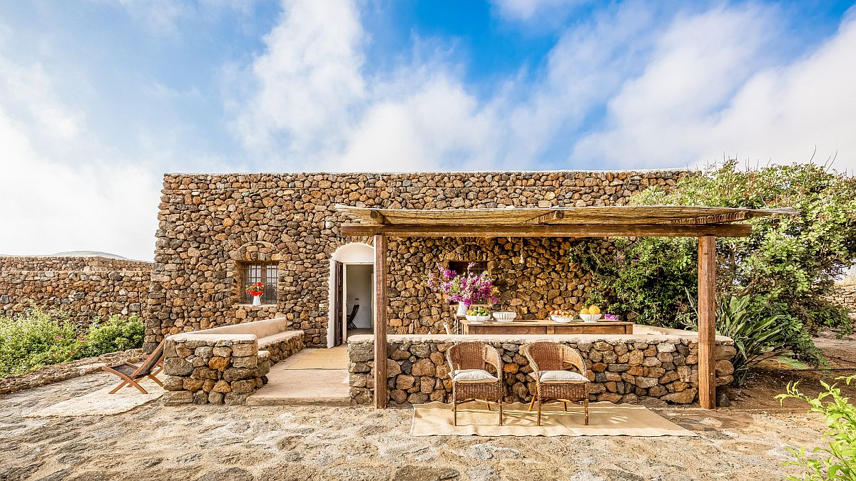 Traditional materials were used to craft this gorgeous home and pergola with Mediterranean style