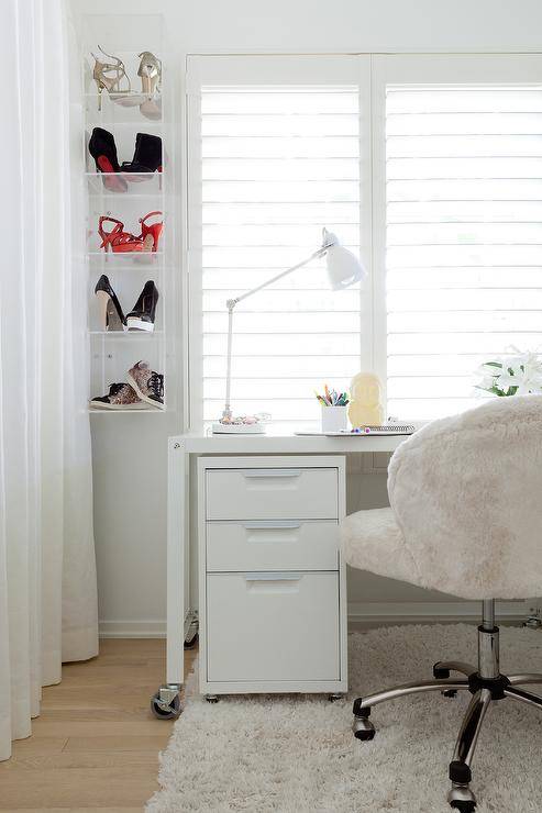 wall mounted shoes in clear boxes next to desk with chair and lamp