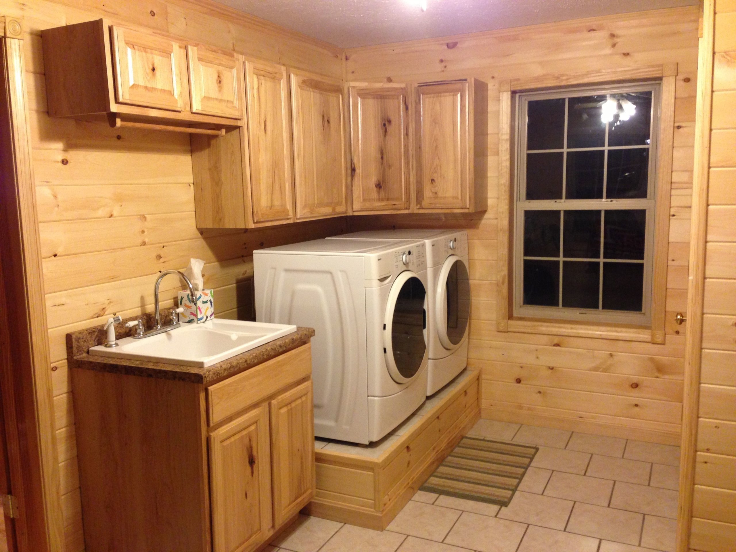 Washer and dryer on a platform beside sink