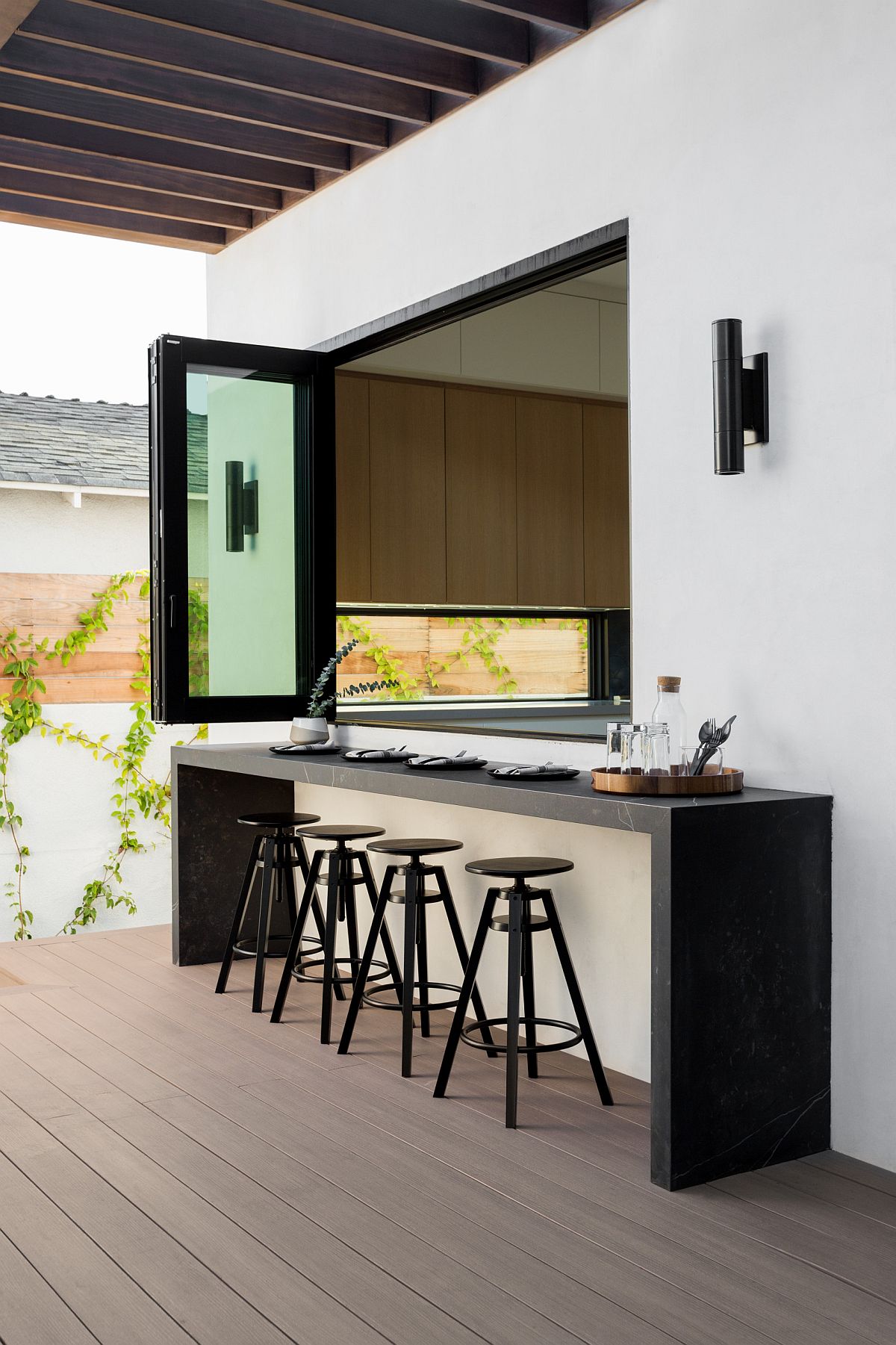 Window connects the kitchen inside the house connects the home with the outdoor kitchen