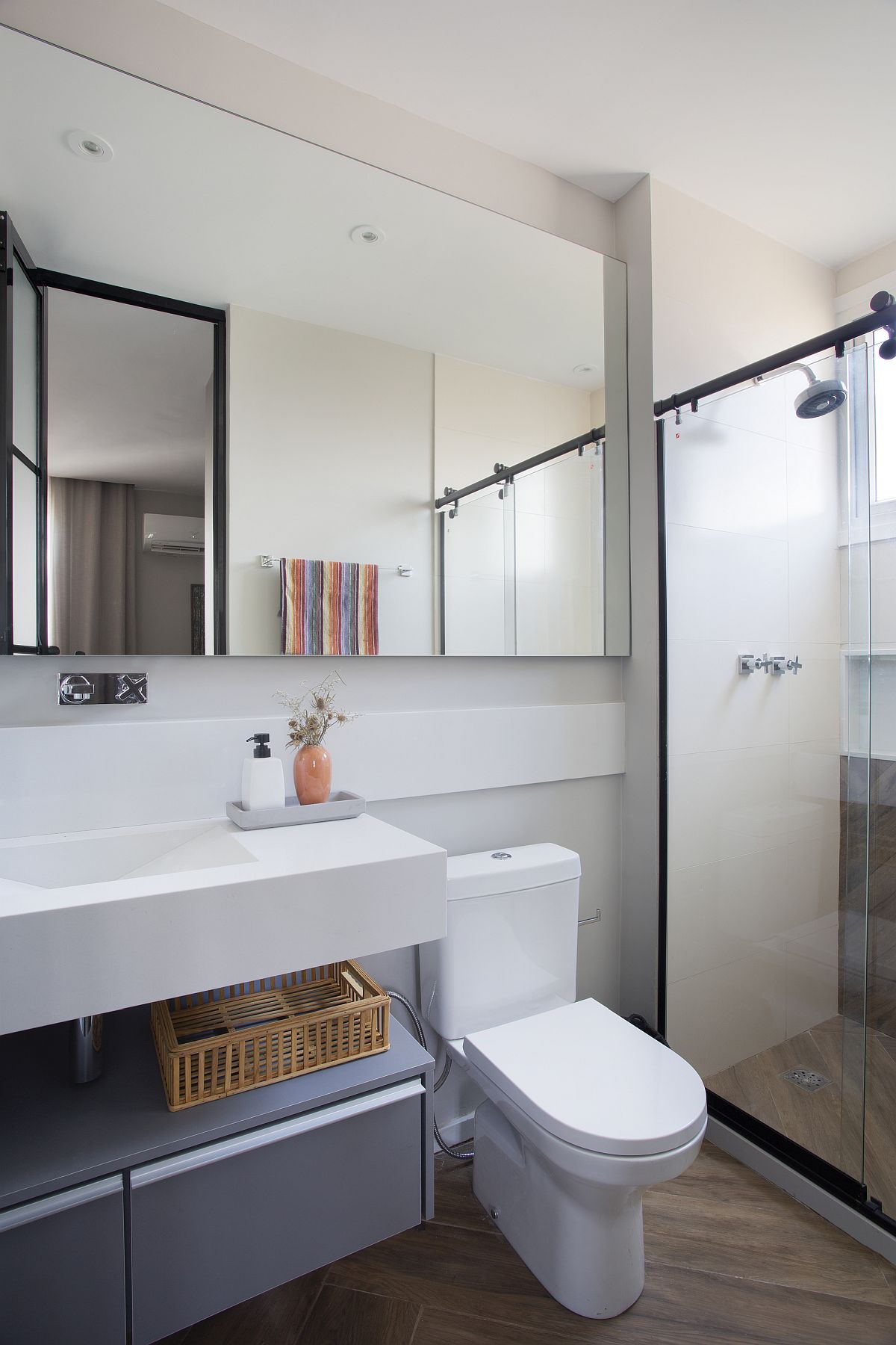 Wooden flooring coupled with gray and white touches in the small modern bathroom