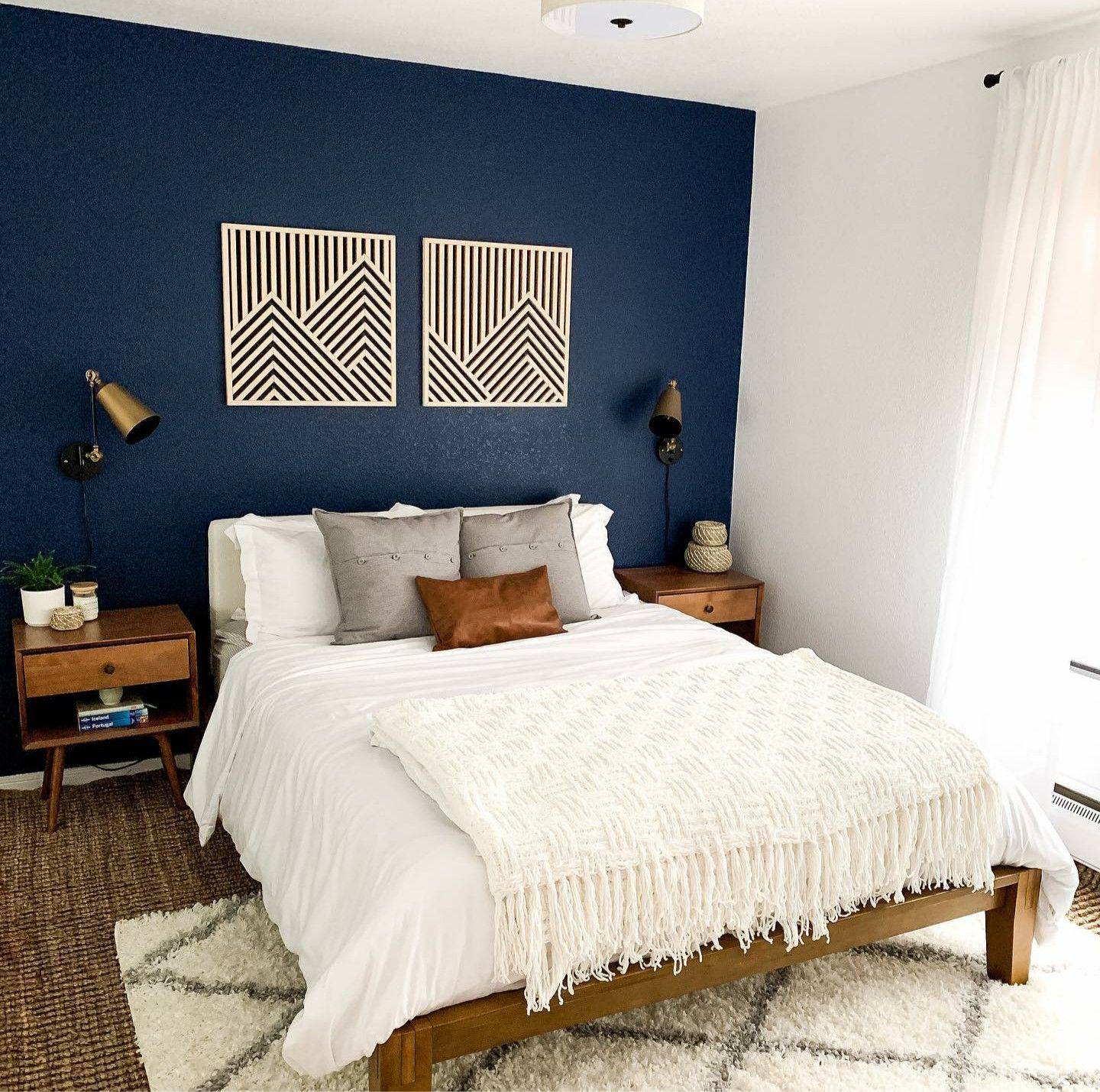 navy blue bedroom accent wall with white linen bedspread