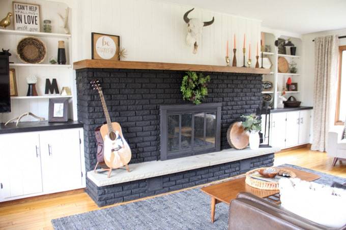 black painted brick fireplace with eclectic decorations