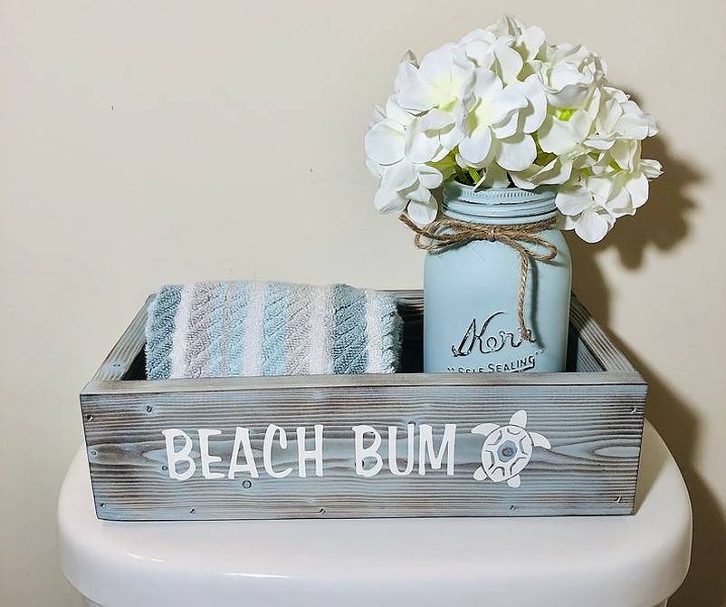 Coastal bathroom decor box with towel and white flower on mason jar