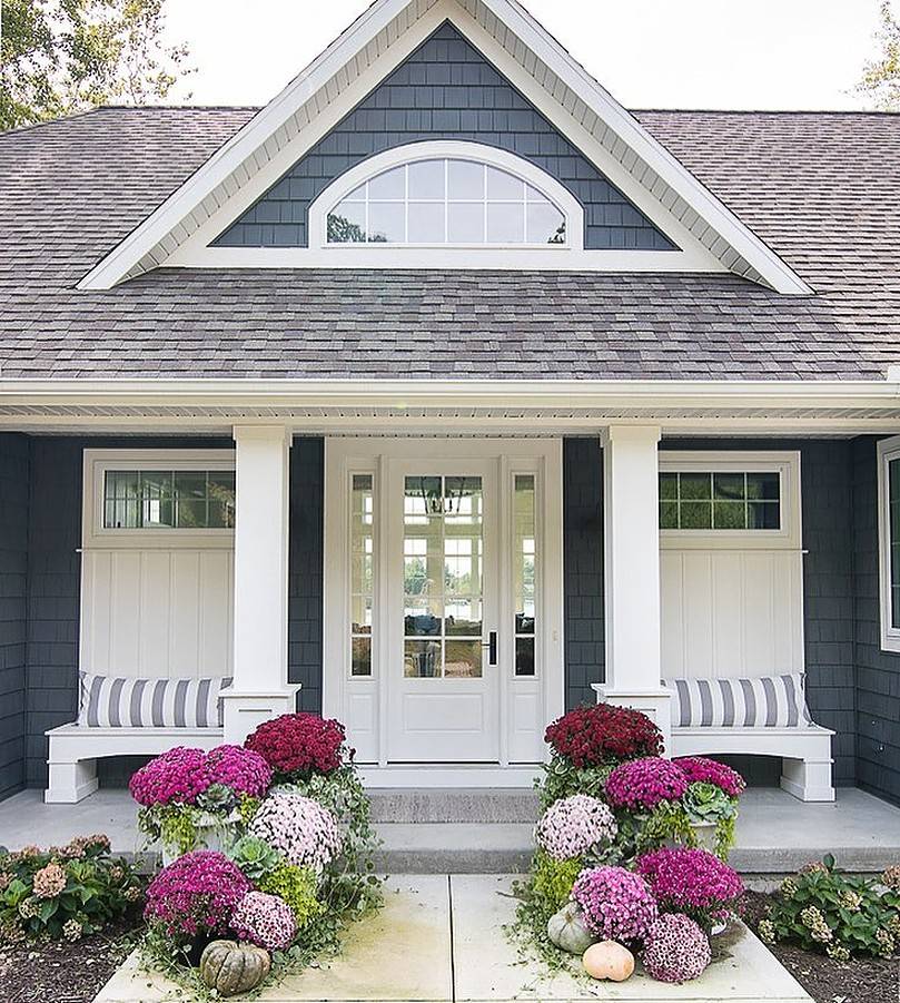 Different shade of purple flowers in front of a house