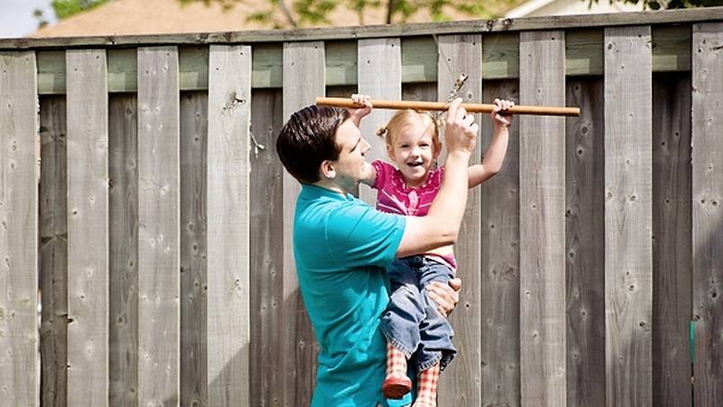 Father holding daughter while on a zip line