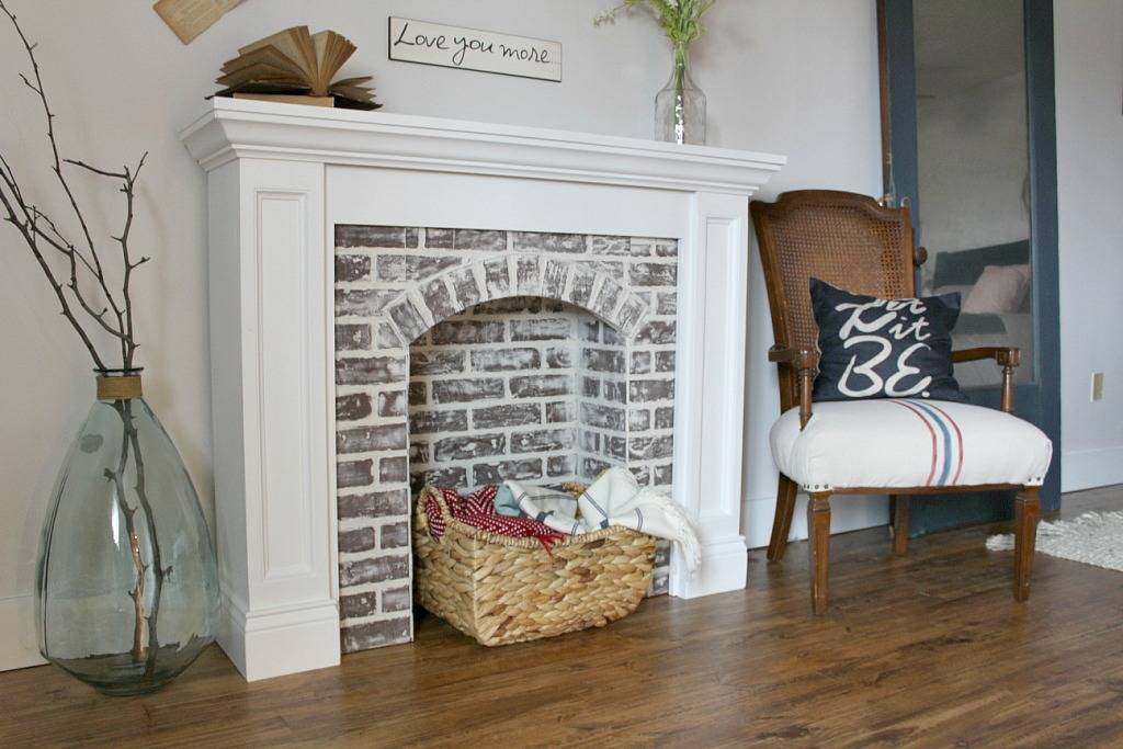 faux brick fireplace with basket of blankets in surround