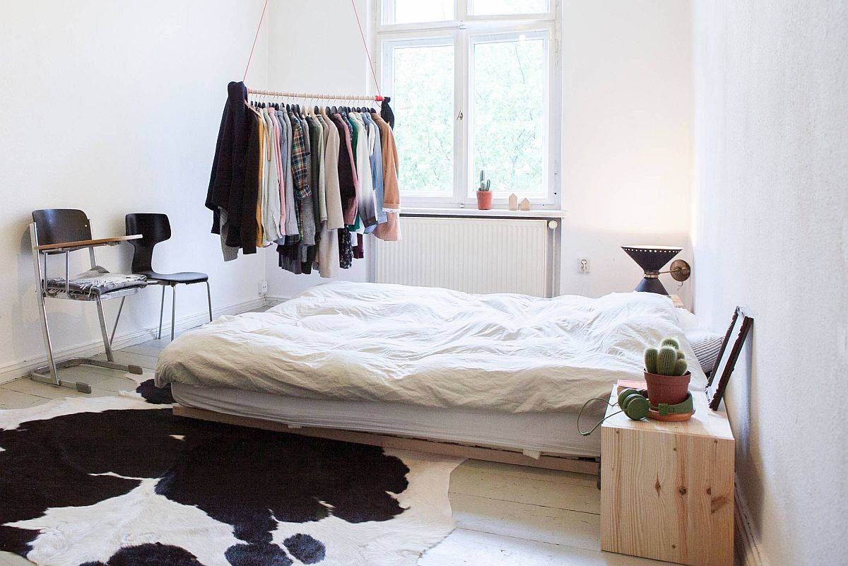 Innovative small closet with metallic bar hanging from the ceiling serves well for those with a minimal wardrobe