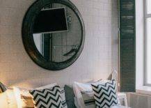 Large round mirror and bull head on the wall above the bed