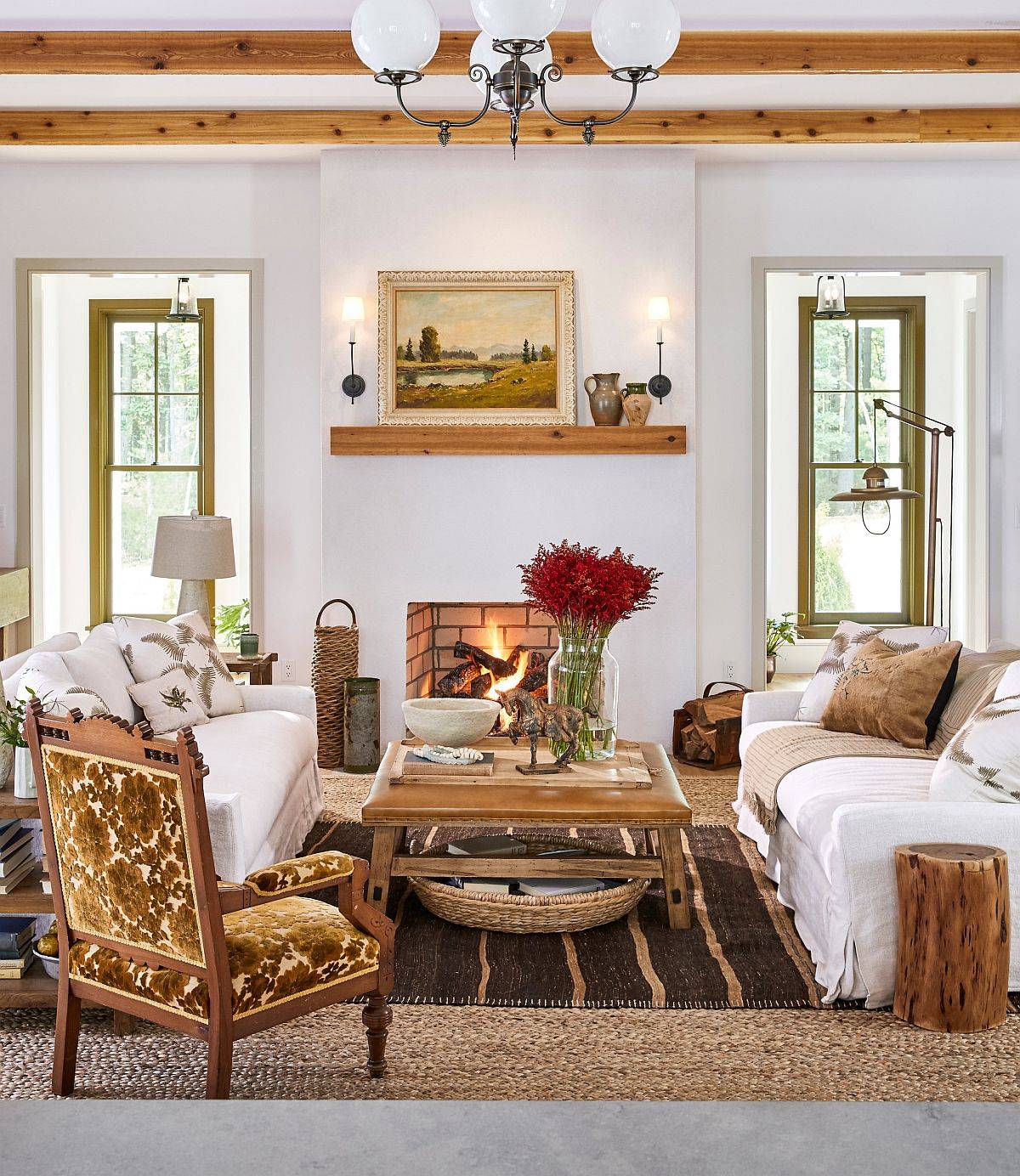 Modern farmhouse style living room in white with fireplace, wooden beams and cozy decor