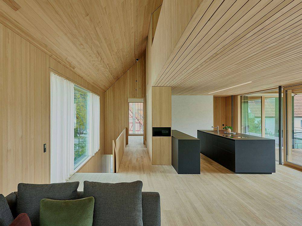 Modern minimal interior of the German home in wood with a polished black kitchen