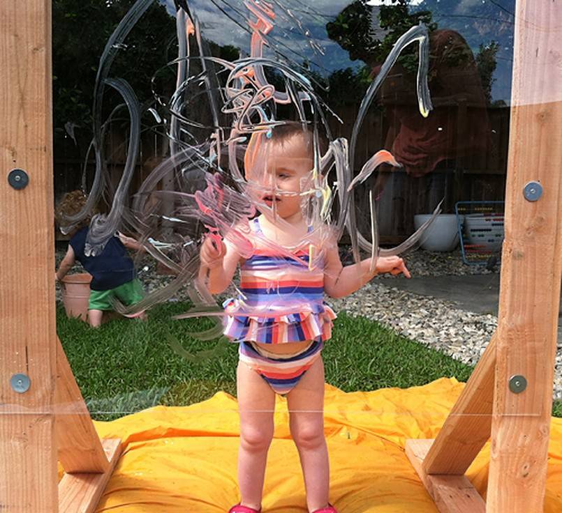 Toddler painting on a clear board