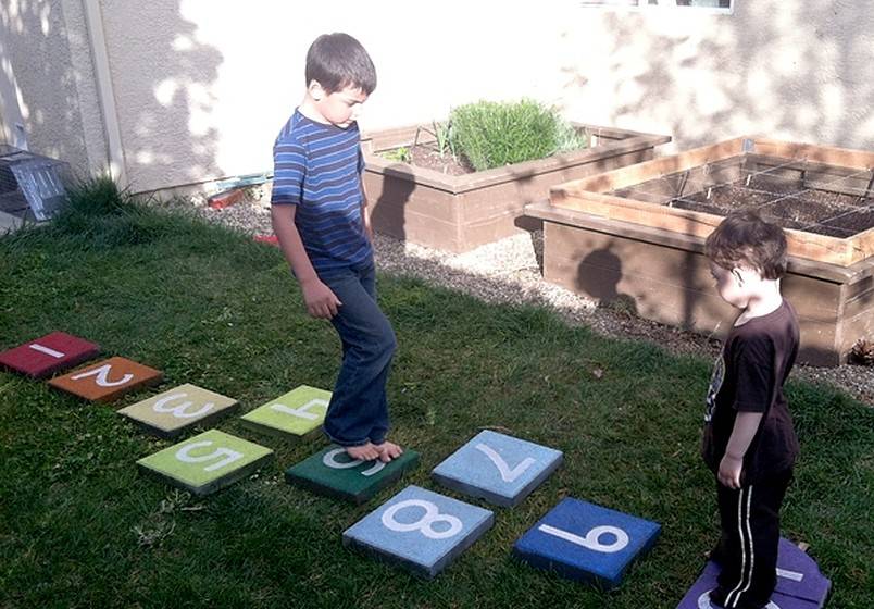 Two boys playing on hopscotch tiles
