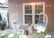 Two hanging white chairs in front of window
