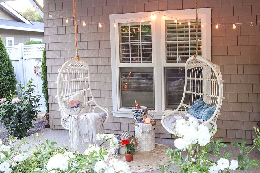 Two hanging white chairs in front of window