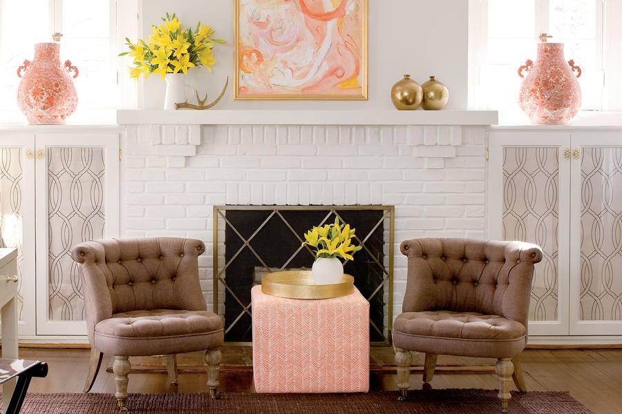 brown armchairs in front of white painted brick fireplace
