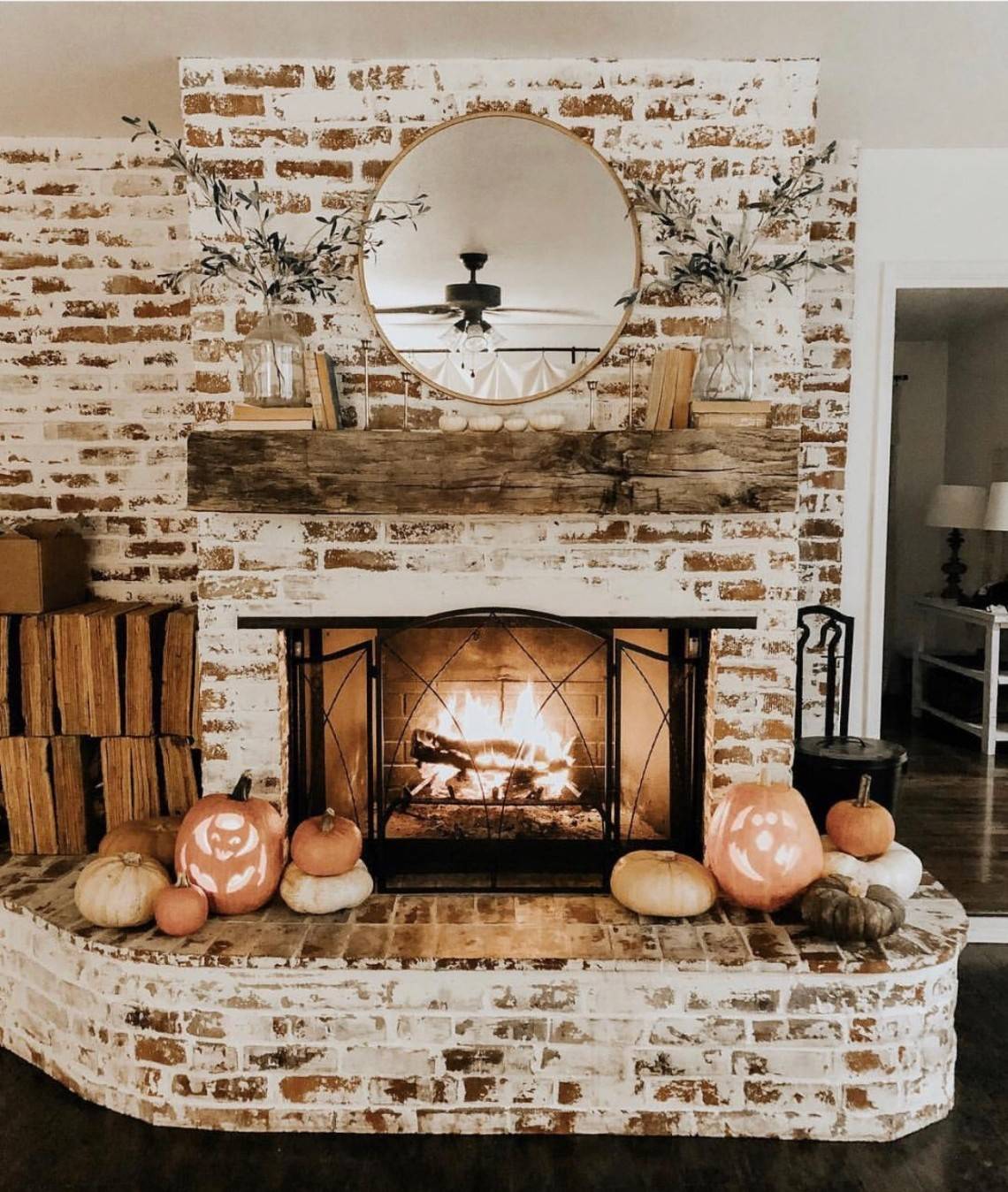 german schmear fireplace with pumpkins and fire lit